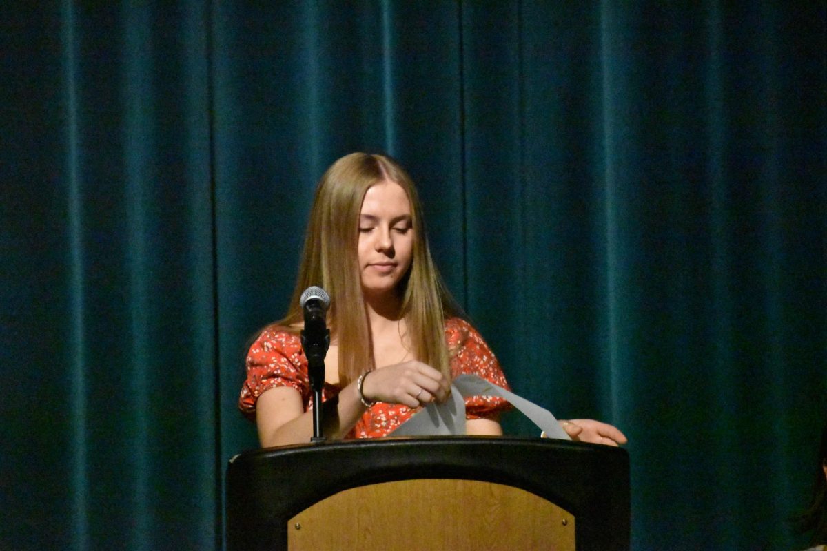 Sonia Florek (12) reads the characteristics associated with NHS membership at the induction ceremony. 