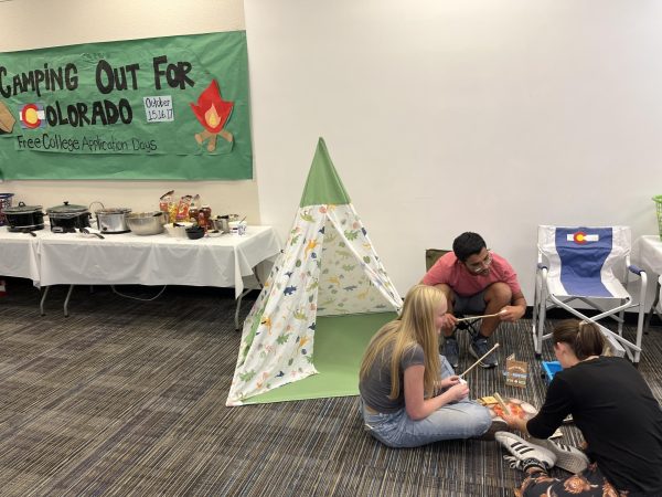 Sydney Ashton (12), Tierney Weems (12) and Divyansh Kulkarni (12) sitting at the fake fireplace at Camping Out For Colorado. Photo courtesy of Mitchell Boycuzk.