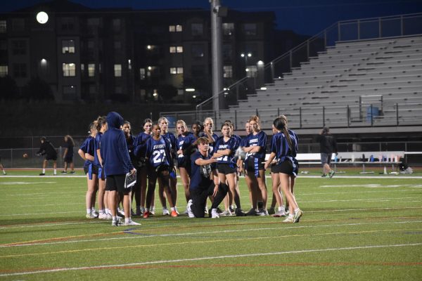 Brady Walden lends advice to the junior team during a huddle.